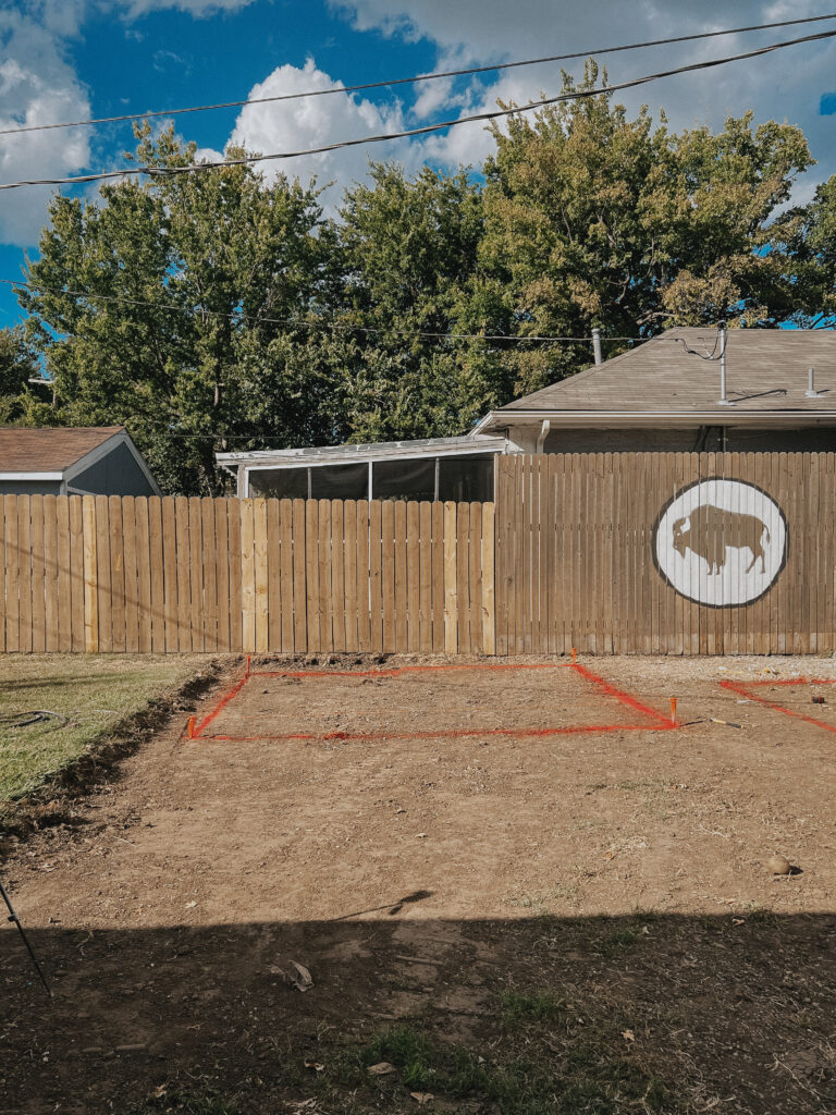 Image of level dirtwork in a backyard, with space for a pergola marked and painted.
